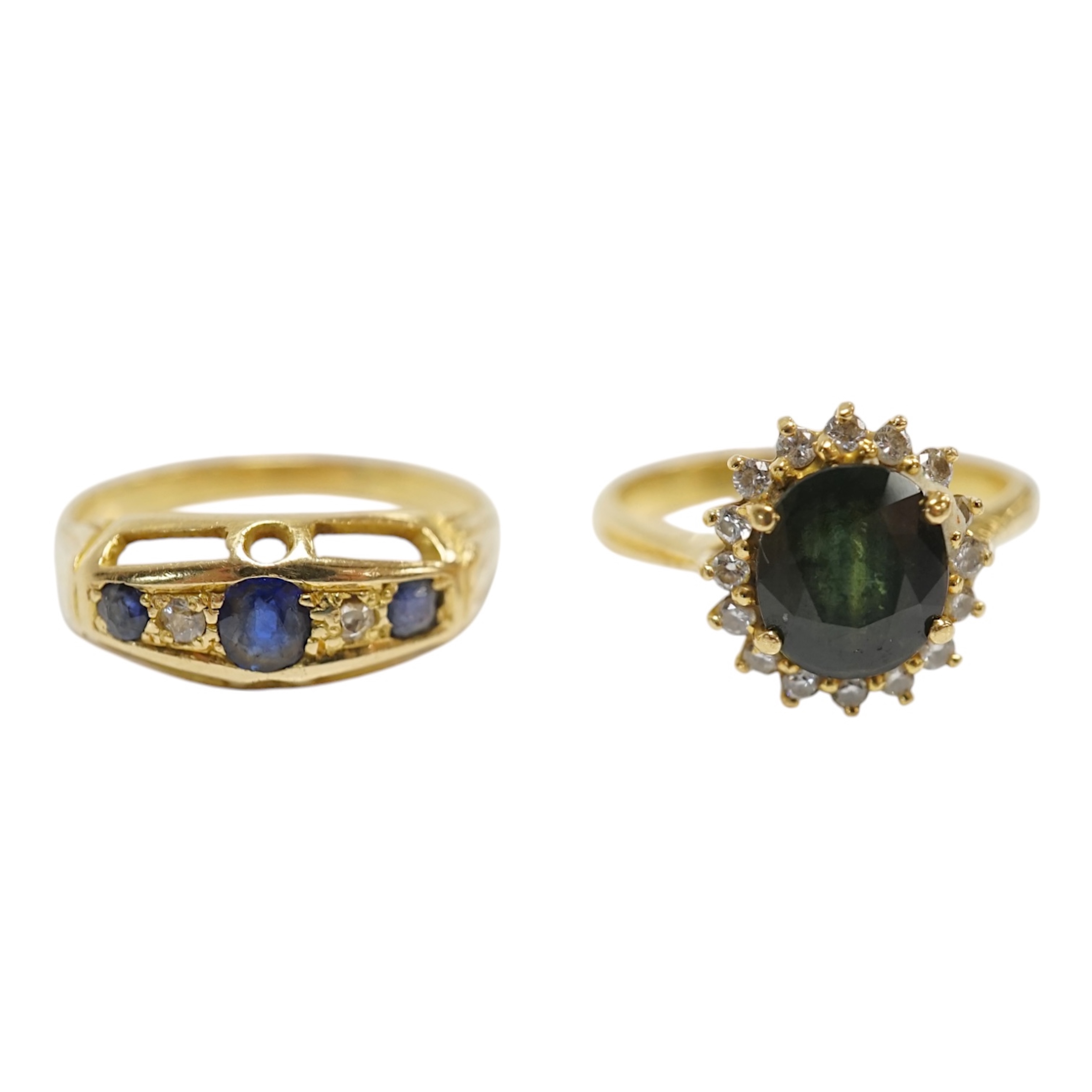 Two yellow metal and gem set rings, including a sapphire? and diamond oval cluster and a three stone sapphire and two stone diamond half hoop, gross weight 7.3 grams. Condition - poor to fair